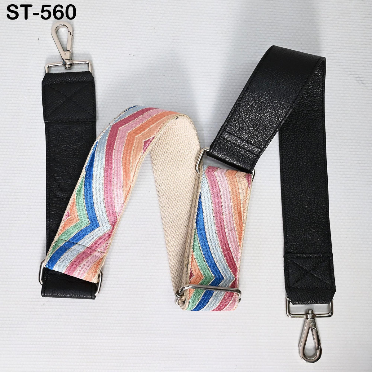 a colorful strap with a black leather strap attached to it, both of which are placed on a white background.